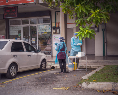Bangi, Malaysia - July 13 2021 Health worker performing COVID-19 sampling taken from individuals by drive thru at the Quick Test Kit Program from a local clinic.のeditorial素材