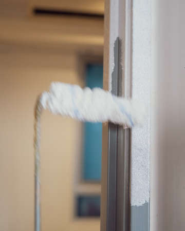 White paint on the door frame. Painting project, DIY at home. Motion roller.の写真素材