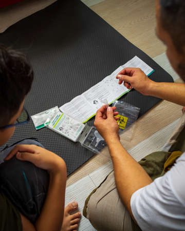 Kuala Lumpur, Malaysia - August 7, 2021 Test Covid at home. COVID-19 home test kit on the floor. Coronavirus saliva test for infection SARS-CoV-2 testing.のeditorial素材