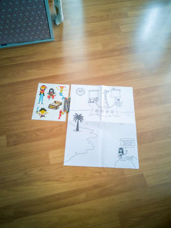 Kuala Lumpur, Malaysia - July 10 Child's colouring activity book on the floor. Little girl's hand showing.のeditorial素材