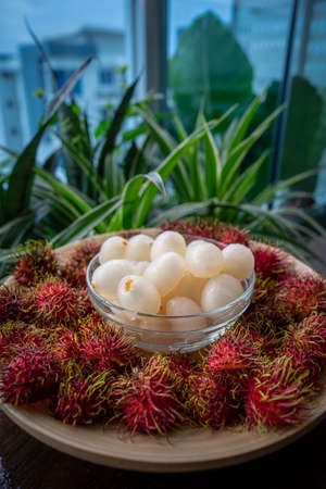 Rambutan, Malaysian sweet delicious fruits in bowl and bamboo plate in the balcony garden.の写真素材