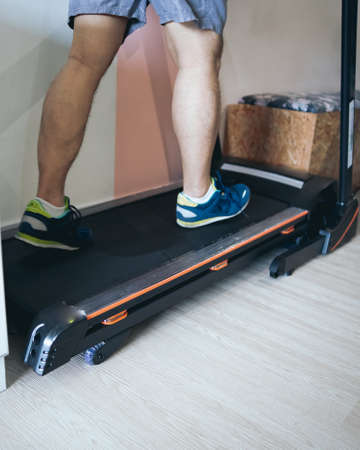 Motion of a Man running in a gym on a treadmill concept for exercising, fitness and healthy lifestyleの写真素材