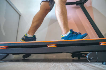 Motion of a Man running in a gym on a treadmill concept for exercising, fitness and healthy lifestyleの写真素材