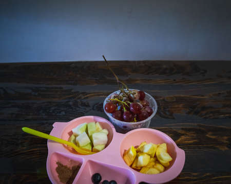 Fun Food for kids. Cute car shaped plate with fresh fruits - apple, grapes, blueberries and guava - for a healthy breakfast.の写真素材
