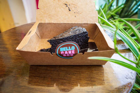 Kuala Lumpur, Malaysia - July 19, 2021 Chocolate cake slice, in a takeaway box with Bello cake & Co label.のeditorial素材