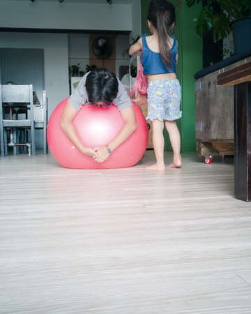 Children playing with gym ball at home.の写真素材