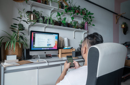 Kuala Lumpur, Malaysia - Aug 3, 2021 Working at home with computer and papers on desk.のeditorial素材