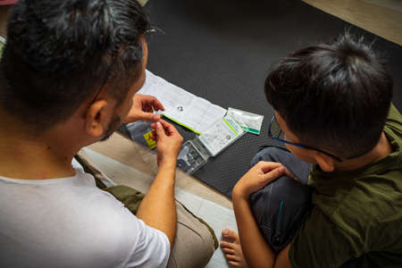 Kuala Lumpur, Malaysia - August 7, 2021 Test Covid at home. COVID-19 home test kit on the floor. Coronavirus saliva test for infection SARS-CoV-2 testing.のeditorial素材