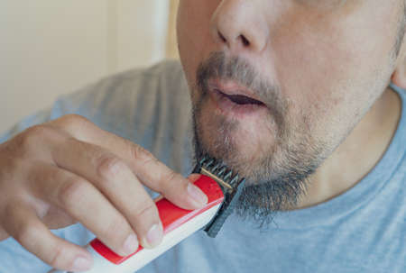 Shaving beard with electric razor machine.の写真素材