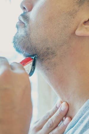Shaving beard with electric razor machine.の写真素材