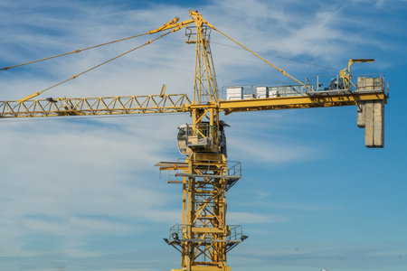 Tower crane against the blue sky. Building under construction. Industrial skylineの写真素材