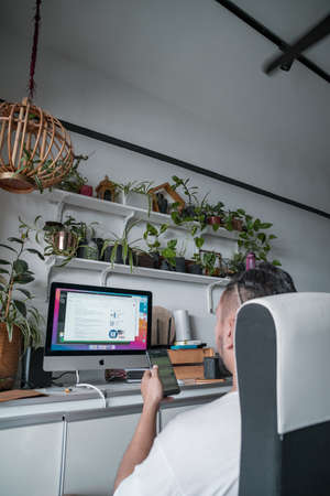 Kuala Lumpur, Malaysia - Aug 3, 2021 working at home with computer and mobile phone