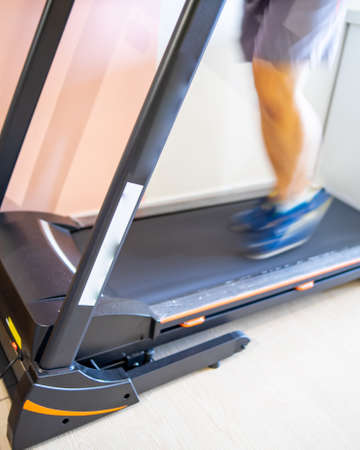 Motion of a Man running in a gym on a treadmill concept for exercising, fitness and healthy lifestyleの写真素材