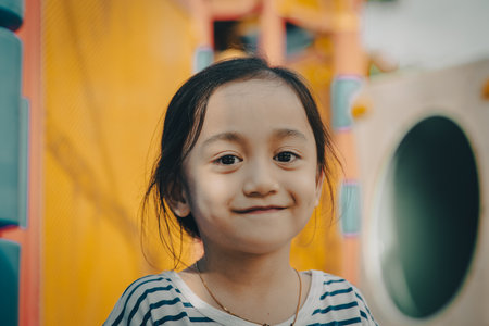 Portrait of a little girl with cute face sitting and looking away.の写真素材