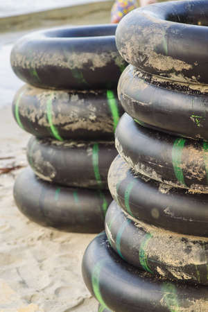 stacked piles of car tire buoys on the beach for rent.の写真素材