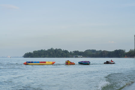 Port Dickson, Malaysia - Nov 5, 2021: Water inflatable boats being pulled by the boat at the beach.