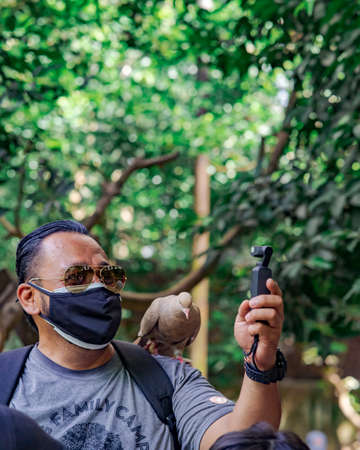 Kuala Lumpur, Malaysia - Oct 14, 2021 : Taking selfie with a Pigeon.のeditorial素材