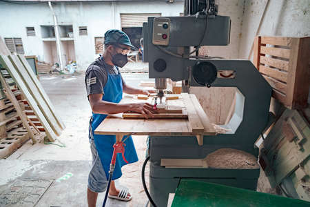 Bangi, Malaysia - Oct 22, 2021 : Worker working with wood cutting machine.のeditorial素材