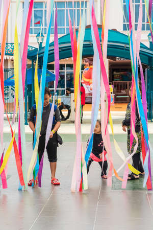 Port Dickson, Malaysia - Nov 19, 2021:  Children entering the Ehsan Water park through colourful string curtains.のeditorial素材