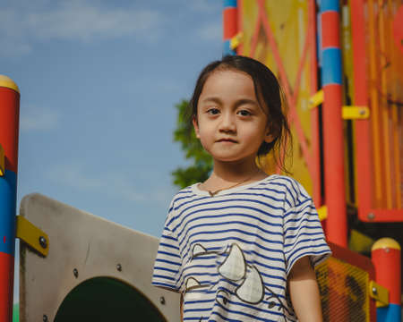 Portrait of a little girl with cute face sitting and looking away.の写真素材