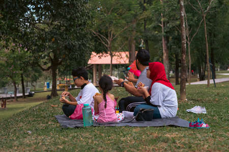 Bangi, Malaysia - Oct 16, 2021 Family picnic and eating at the park.のeditorial素材