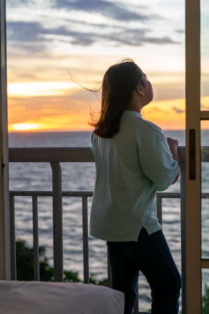 Young girl enjoys life in the sunset of summer sun, in motion.の写真素材