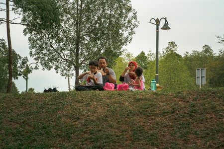 Bangi, Malaysia - Oct 16, 2021 Family picnic and eating at the park.のeditorial素材
