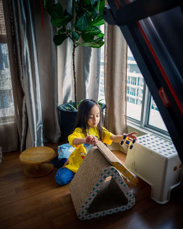 Little girl playing at home in an apartment.