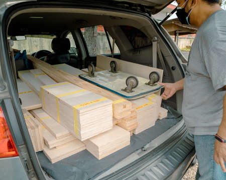 Wooden plywoods stacked and labeled with measurement inside the car.の写真素材