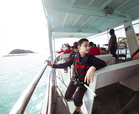Young boy wearing life jacket and snorkeling gears on the boat.の写真素材
