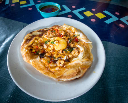 roti sarang burung on the table. It is pratha looks like bird nest with half cook eggs in the...