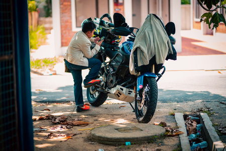 Terengganu, Malaysia - June 26, 2022 : 2012 Yamaha XT1200Z 'Super TÃ©nÃ©rÃ©' motorcycle with child using mobile phone near.のeditorial素材