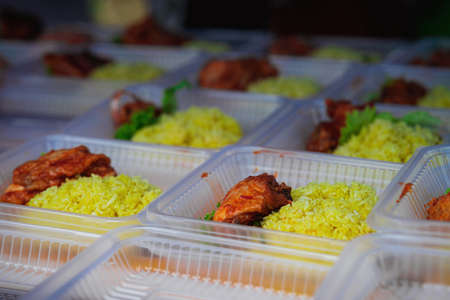 Typical Malaysian daily food at street stall or bazaar called Nasi Ayam Tomato packed in bio degradable plastic container .の写真素材