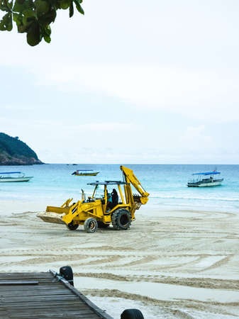 Excavator doing reconstruction and improvement of a sandy beach.の写真素材