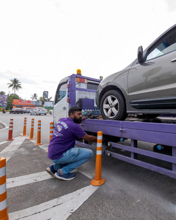 Perak, Malaysia - Aug 7, 2022 : Setting up the broken car on the truck for transportation.のeditorial素材