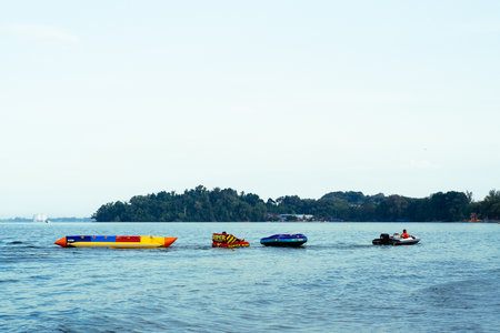 Port Dickson, Malaysia - Nov 5, 2021: Water inflatable boats being pulled by the boat at the beach.のeditorial素材