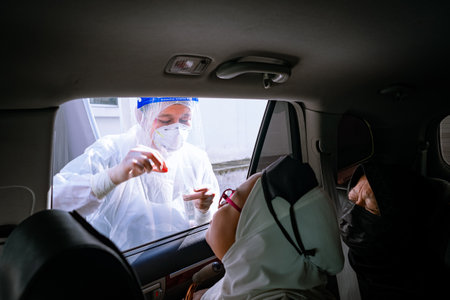 Bangi, Malaysia - Feb 15, 2022: A young girl is taking a PCR swab test by drive thru lab.のeditorial素材