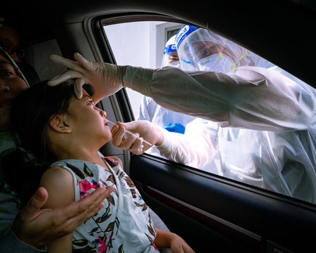 Bangi, Malaysia - Feb 15, 2022: A little girl is taking a PCR swab test by drive thru lab.のeditorial素材