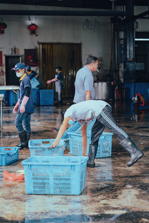 Sekinchan, Malaysia - Oct 6, 2022 Fishermans sorting out the fish catch in containers at the dock.のeditorial素材