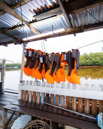 Terengganu, Malaysia - May 9, 2022: life jacket in orange color hanging on the wooden hut.