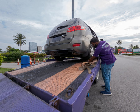 Perak, Malaysia - Aug 7, 2022 : Setting up the broken car on the truck for transportation.のeditorial素材