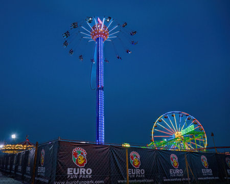 Bukit Jalil, Malaysia - Aug 16, 2022 Euro Fun Park fun fair at night. Space flyer attraction with people.のeditorial素材