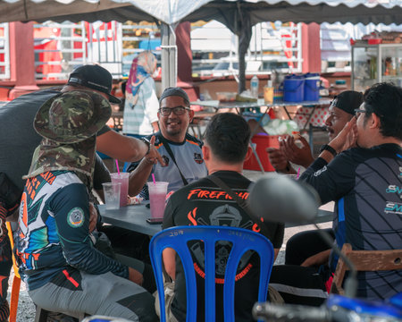 Pahang, Malaysia - Sept 24, 2022 Malay men are chatting together at the local cafe with friends.