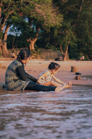 children sitting by the beach playing sand.の写真素材