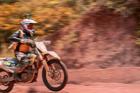 Pahang, Malaysia - Sept 24, 2022 Panning motion view of the Enduro bike rider on action on the sand terrain during practice.のeditorial素材