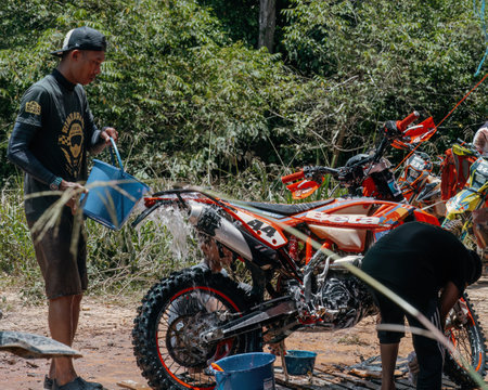 Pahang, Malaysia - Sept 24, 2022 Washing motorcross bike after the practice.のeditorial素材