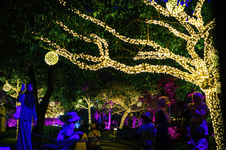Putrajaya, Malaysia - July 18, 2022 Led lights on the trees in the garden. Neon fairy party with visitors.のeditorial素材