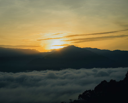 Golden surnise behind the Titiwangsa range mountains in Lenggong, Perak with sea clouds.の写真素材