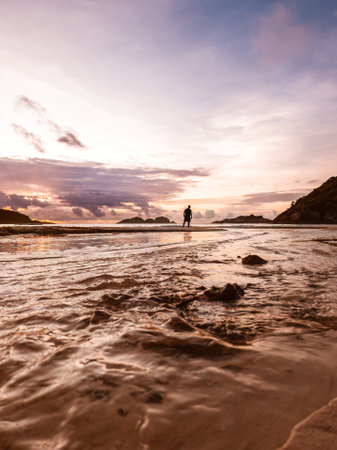 Sunrise reflections on the beach sand. Textured and watery sandy beach.の写真素材
