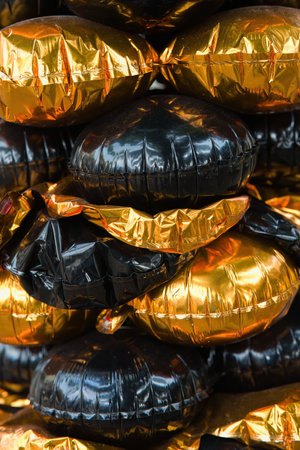 Closeup of the Black and Gold Yellow foil baloons on top of each other.の写真素材